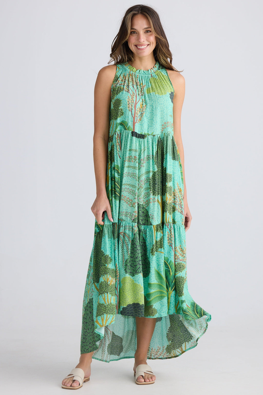 Woman wearing a green and blue patterned dress on a white background