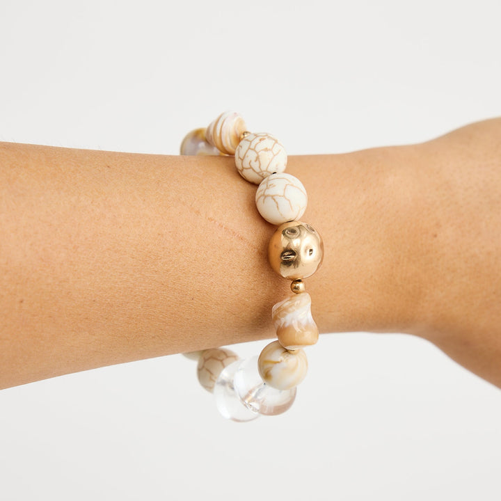 Beaded bracelet on a wrist against a plain background
