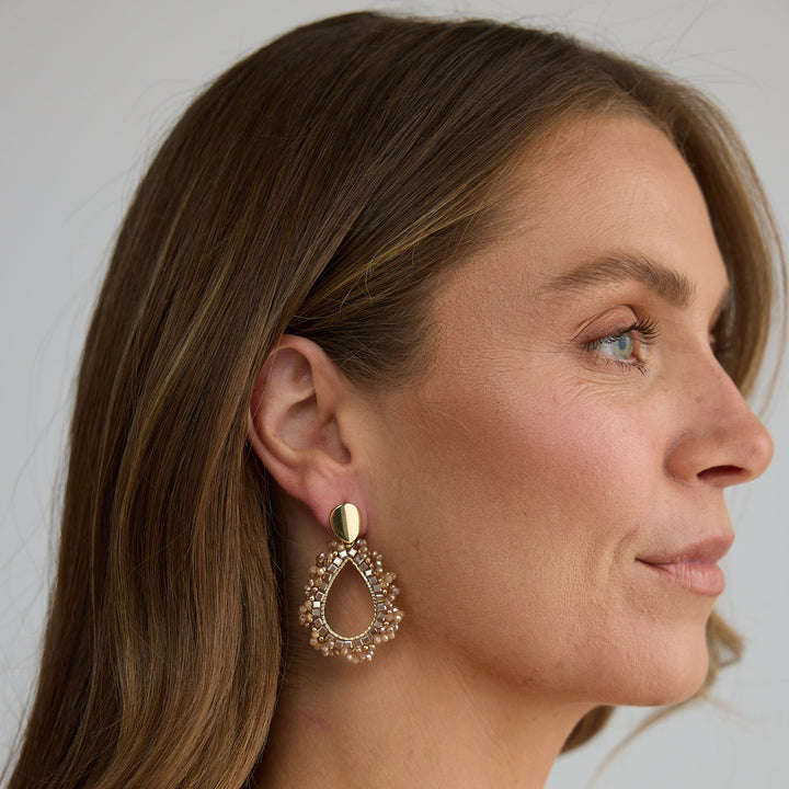 Woman wearing a gold earring with a white background