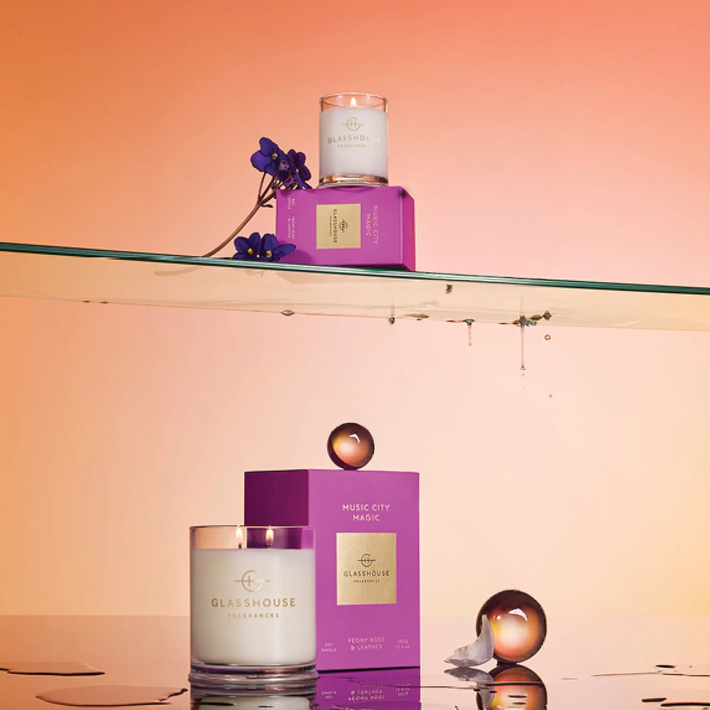 Glasshouse candles and packaging on a glass shelf with a gradient background