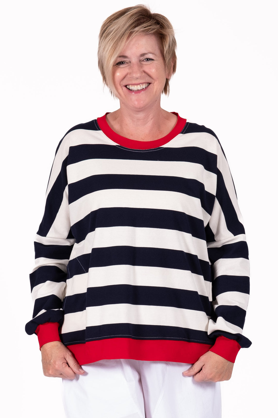 Person wearing a black and white striped sweater with red trim on a white background