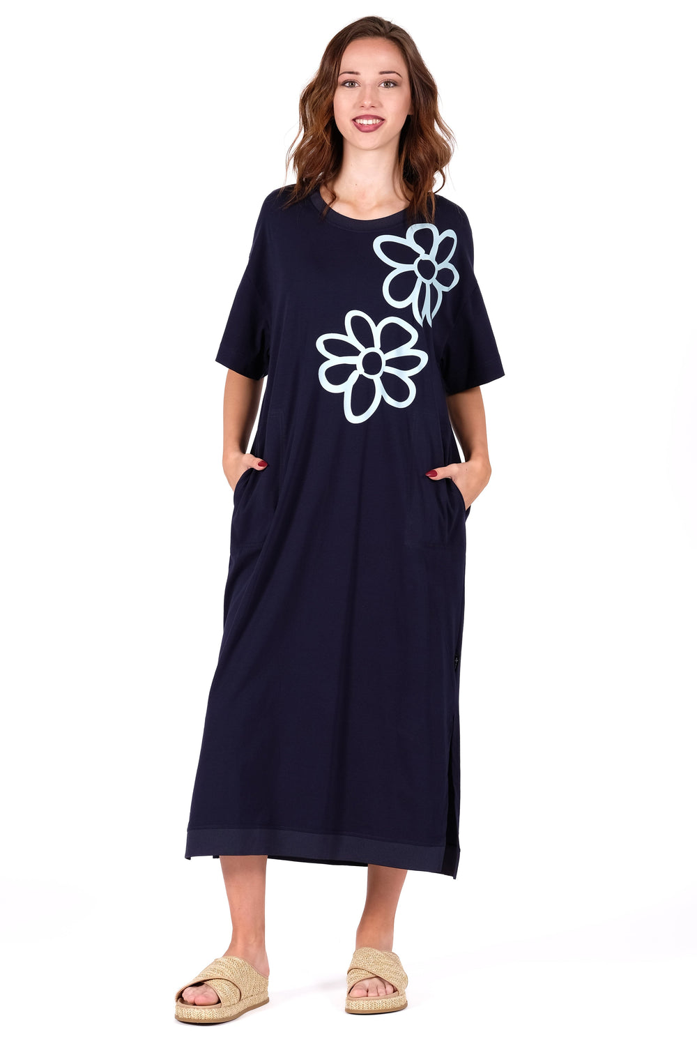 Woman wearing a navy dress with white floral designs on a white background