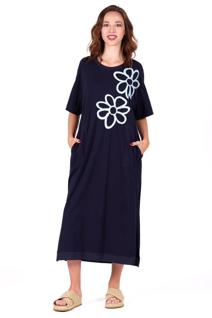 Woman wearing a navy dress with white floral designs on a white background