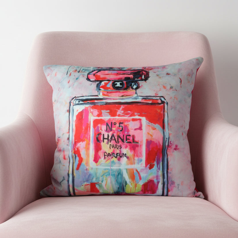 Decorative pillow with a colorful Chanel No. 5 perfume bottle design on a white background
