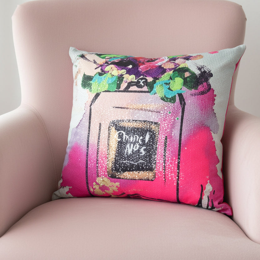 Decorative pillow with a colorful Chanel bottle design on a white background
