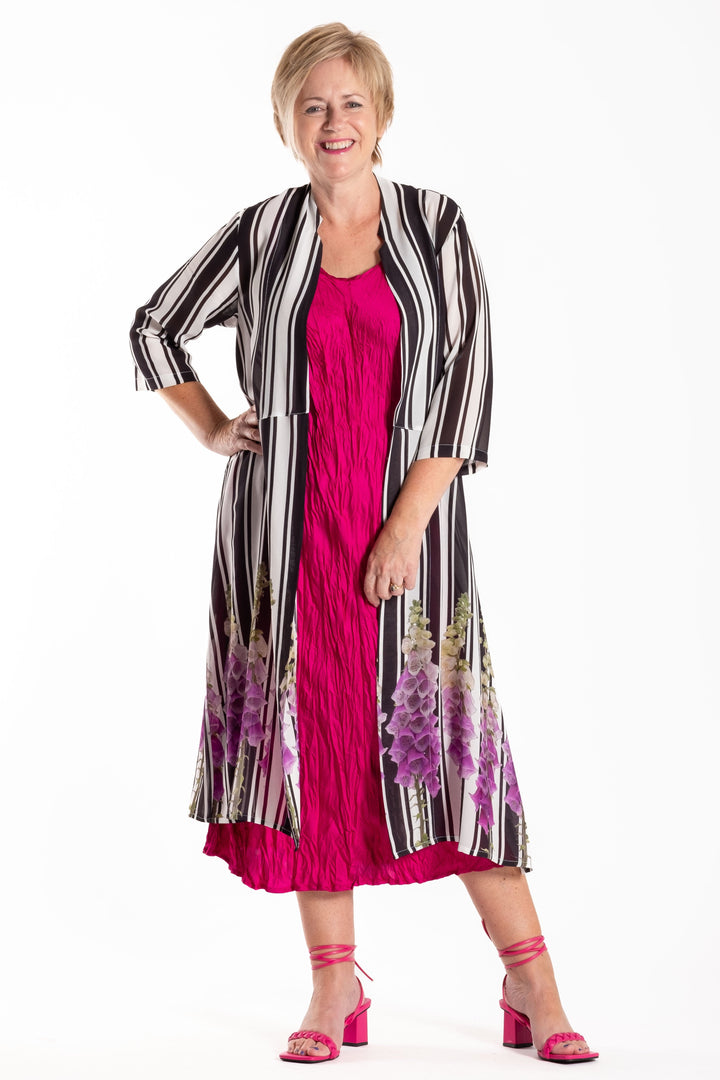 Woman wearing a pink dress with a black and white patterned jacket on a white background