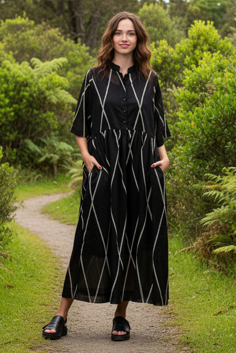 Woman wearing a black outfit with white geometric patterns on a white background