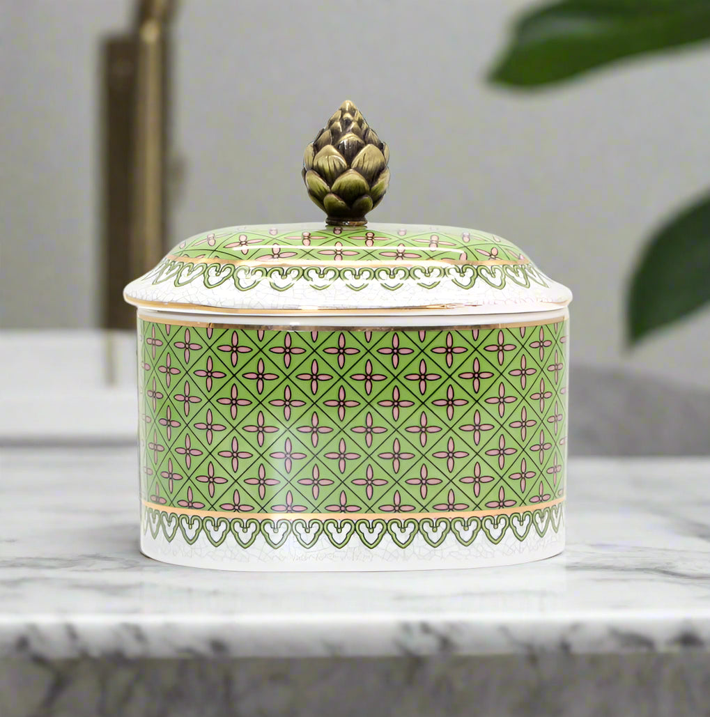 Decorative ceramic jar with green patterned lid on a white background