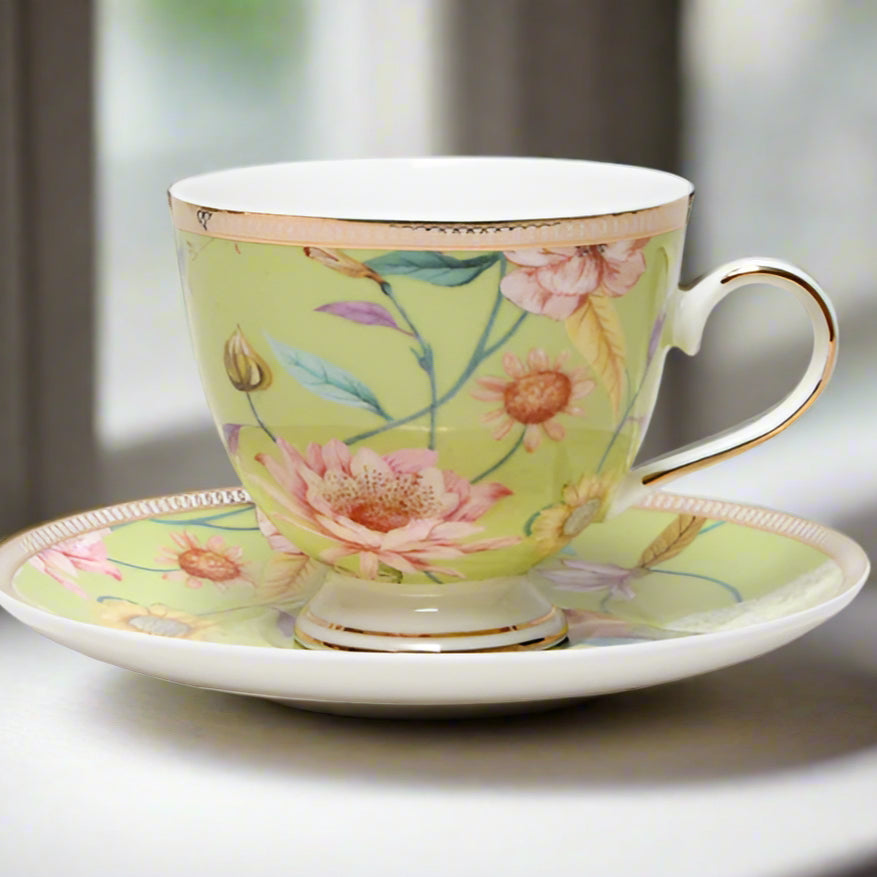 Floral and gold teacup and saucer set on a white background