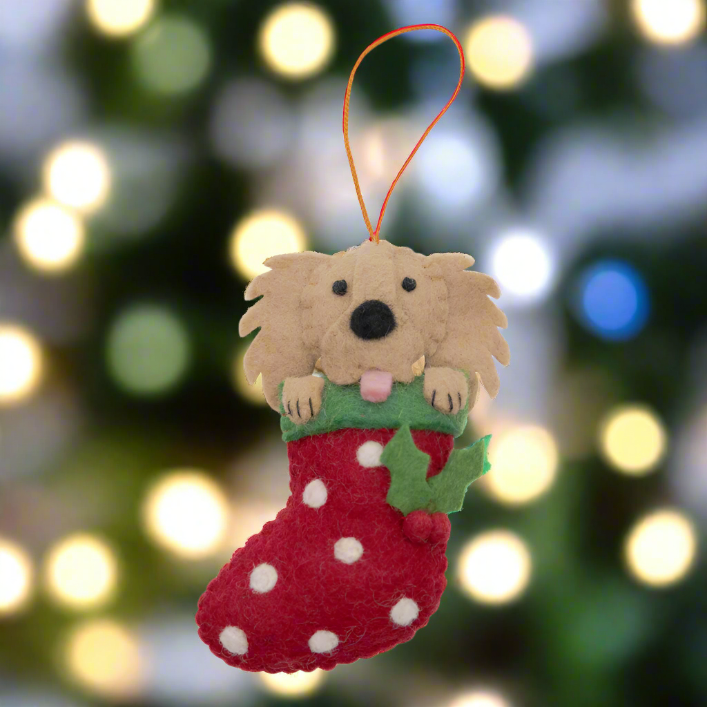 Felt dog ornament in a red stocking with white polka dots on a white background