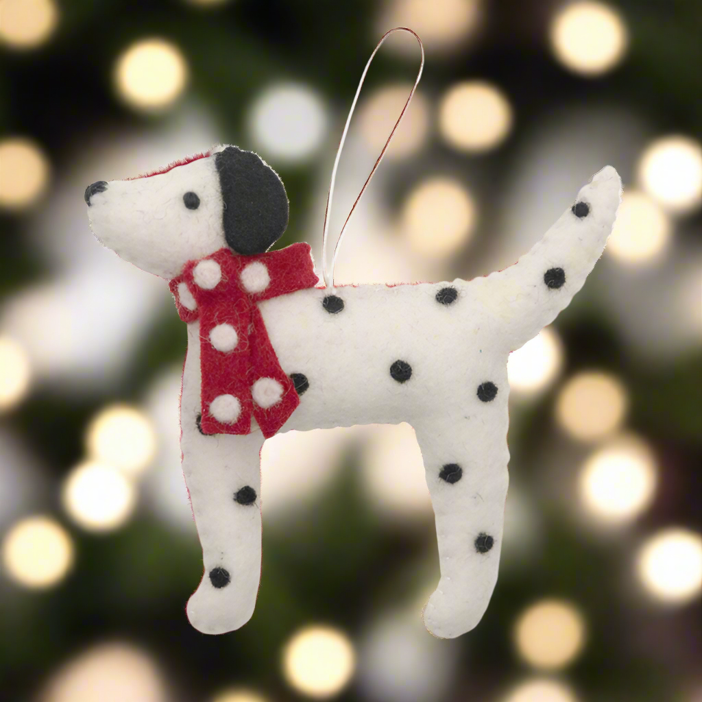 Felt dog ornament with black spots and a red polka dot scarf on a white background