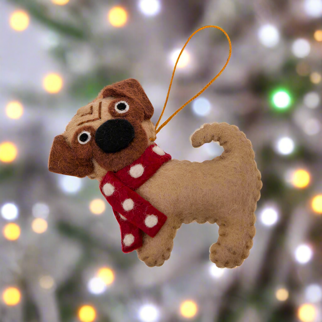 Dog-shaped ornament with a red scarf on a white background