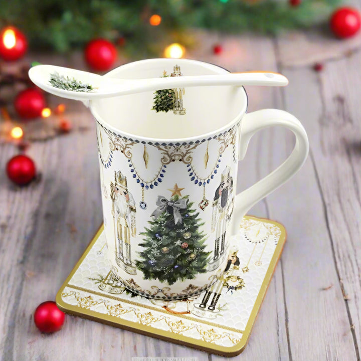 Decorative mug with Christmas tree design, spoon, and coaster on a white background