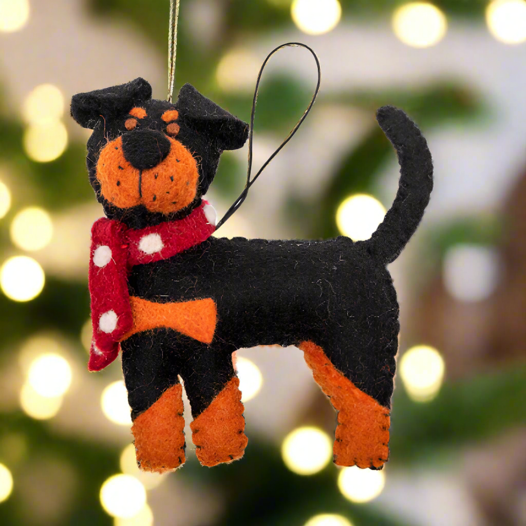 Dog-shaped ornament with a red scarf on a white background