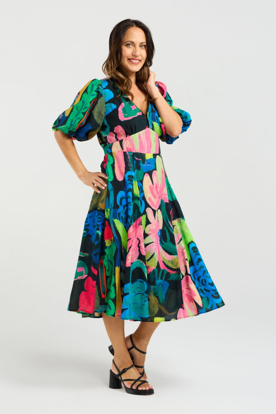 Woman wearing a colorful floral dress on a white background