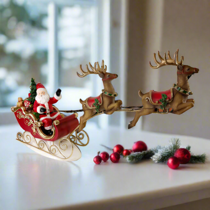 Decorative model of Santa Claus in a sleigh pulled by reindeer on a white background
