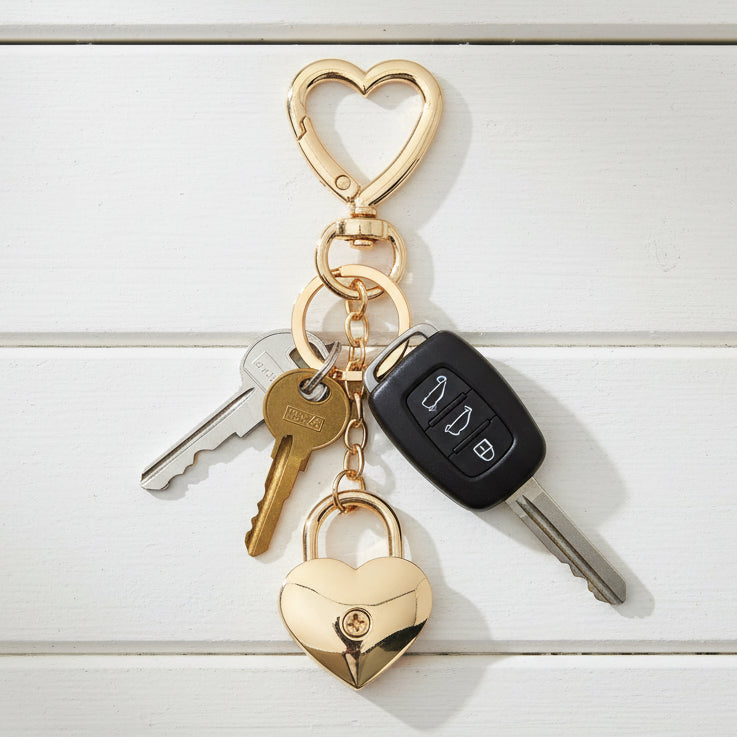 Gold heart-shaped keychain with lock on a white background
