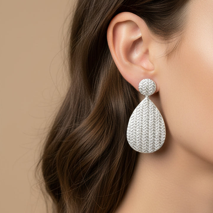Pair of silver teardrop earrings on a white background