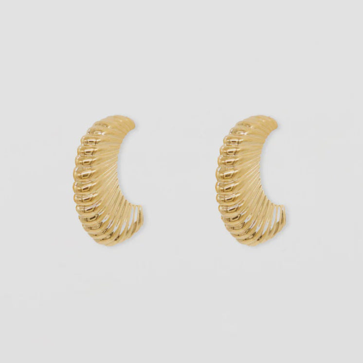 Gold hoop earrings on a light gray background