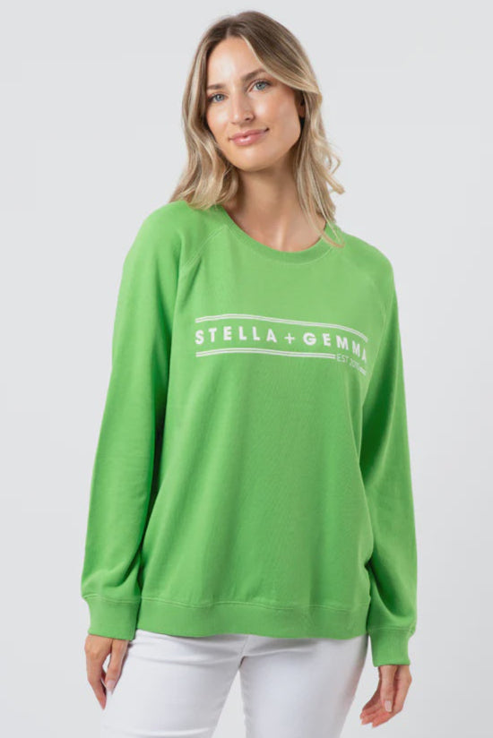 Woman wearing a green sweatshirt with 'Stella & Gemma' logo on a white background