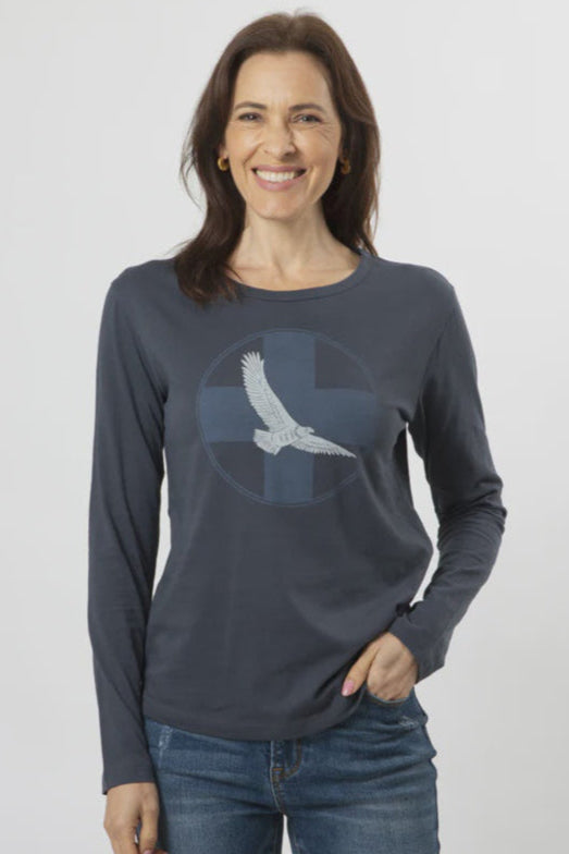 Woman wearing a dark gray long-sleeve shirt with an eagle design on a plain background