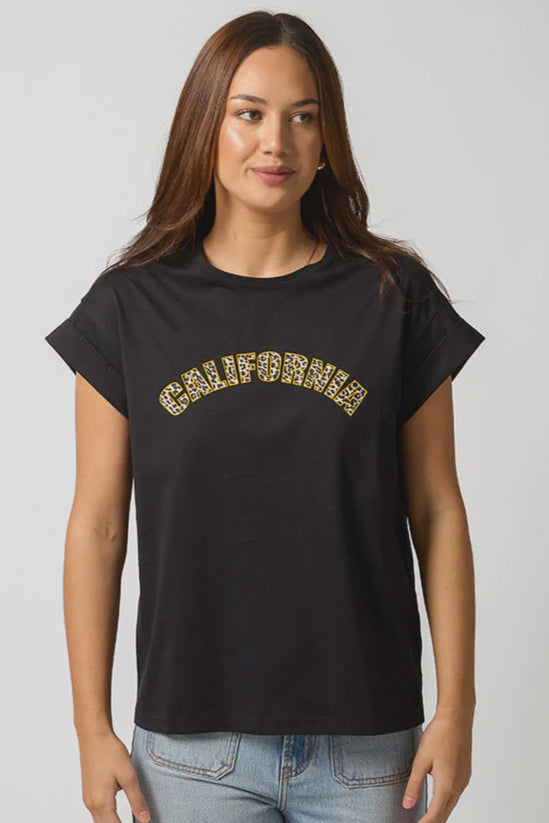 Woman wearing a black t-shirt with 'California' printed in gold on a plain background