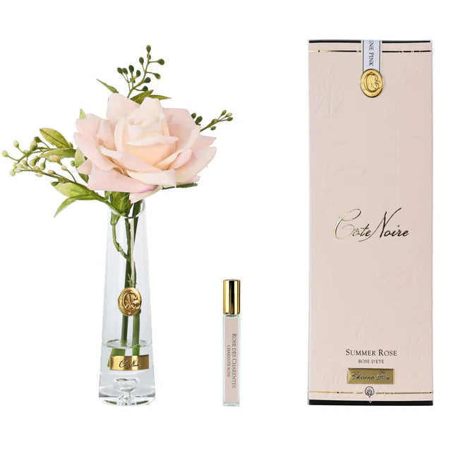 Set with a rose in a vase and a small bottle labeled 'Credo Nobile' on a white background