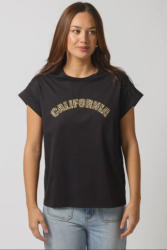 Woman wearing a black t-shirt with 'California' printed in gold on a plain background