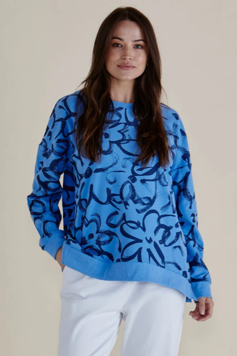Woman wearing a blue patterned sweater against a beige background