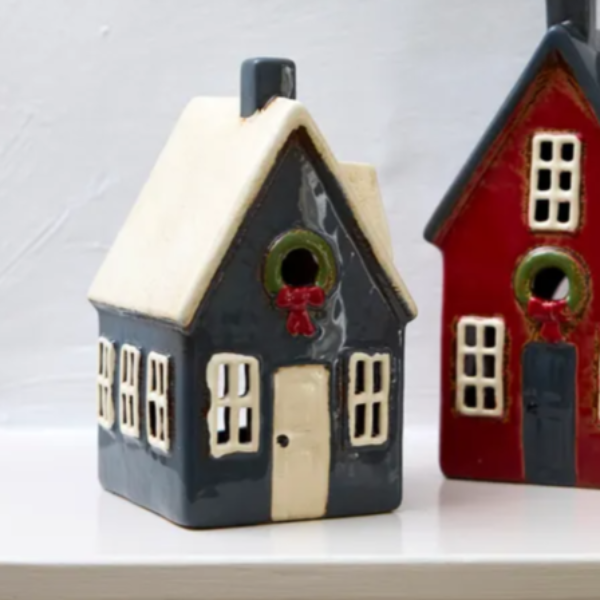 Two small house-shaped birdhouses on a white surface with a light gray background