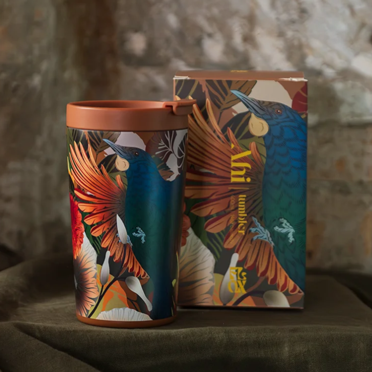Colorful flox tumbler and box with bird design on a textured surface
