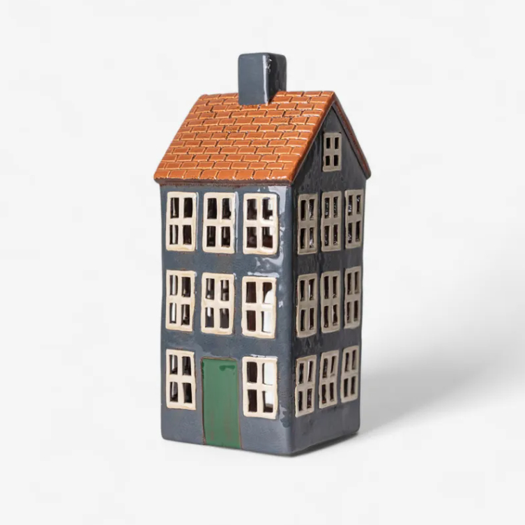Ceramic house-shaped vase with a brown roof and green door on a white background