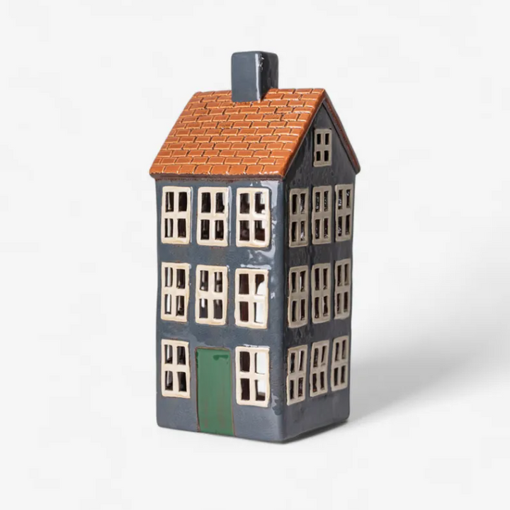 Ceramic house-shaped vase with a brown roof and green door on a white background