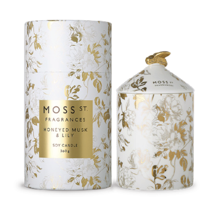 Moss St Fragrances Honeyed Musk & Lily soy candle in a white cylindrical tin with gold foil floral pattern and a matching small jar with a gold lid, shown on a white background.
