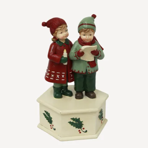 Decorative figurine of two children in winter clothing on a white background