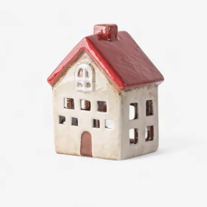 Small ceramic house with a red roof on a white background
