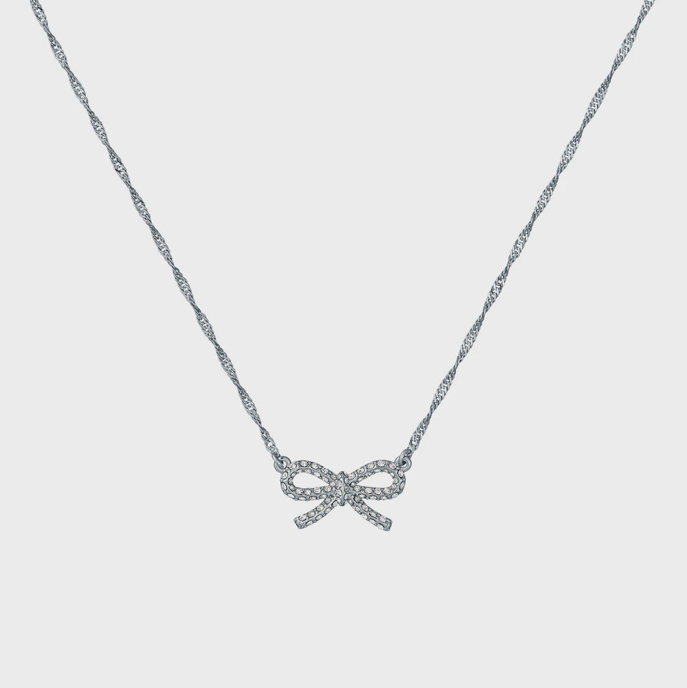 Silver bow-shaped necklace on a light gray background