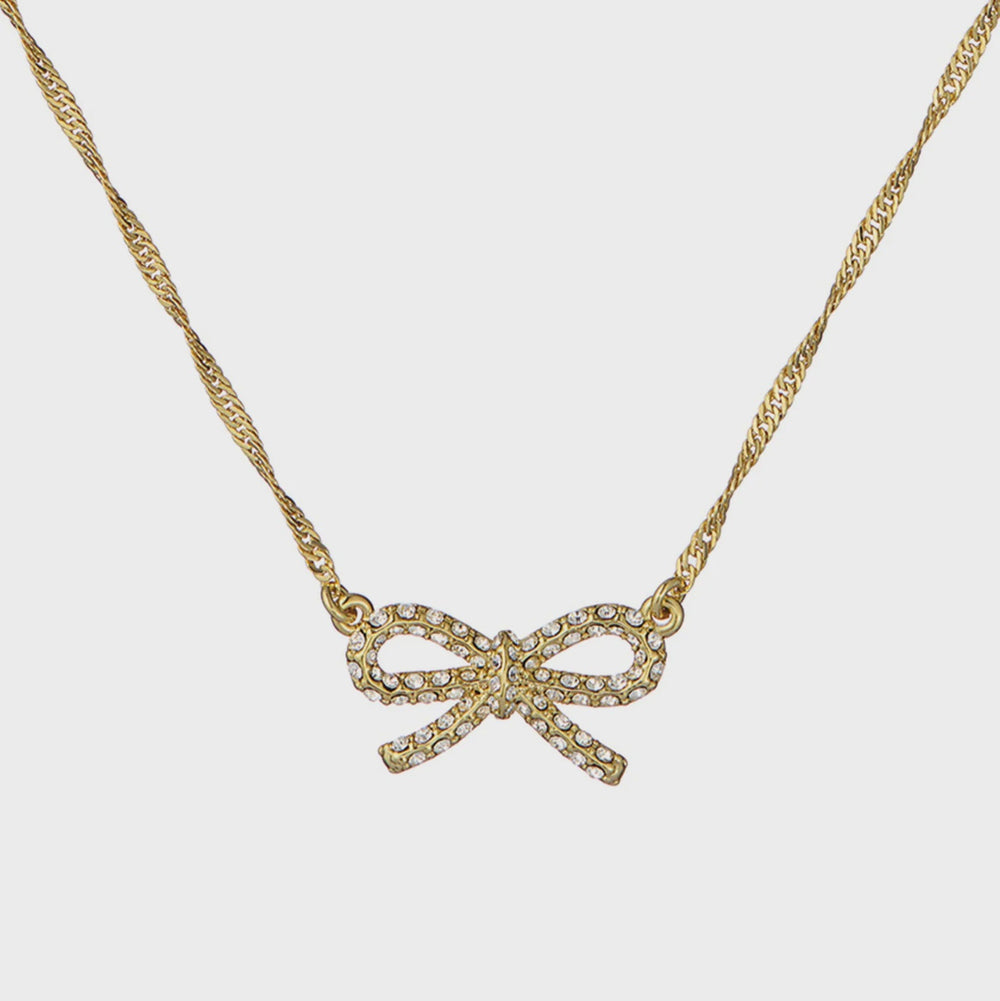 Gold bow-shaped necklace on a light gray background