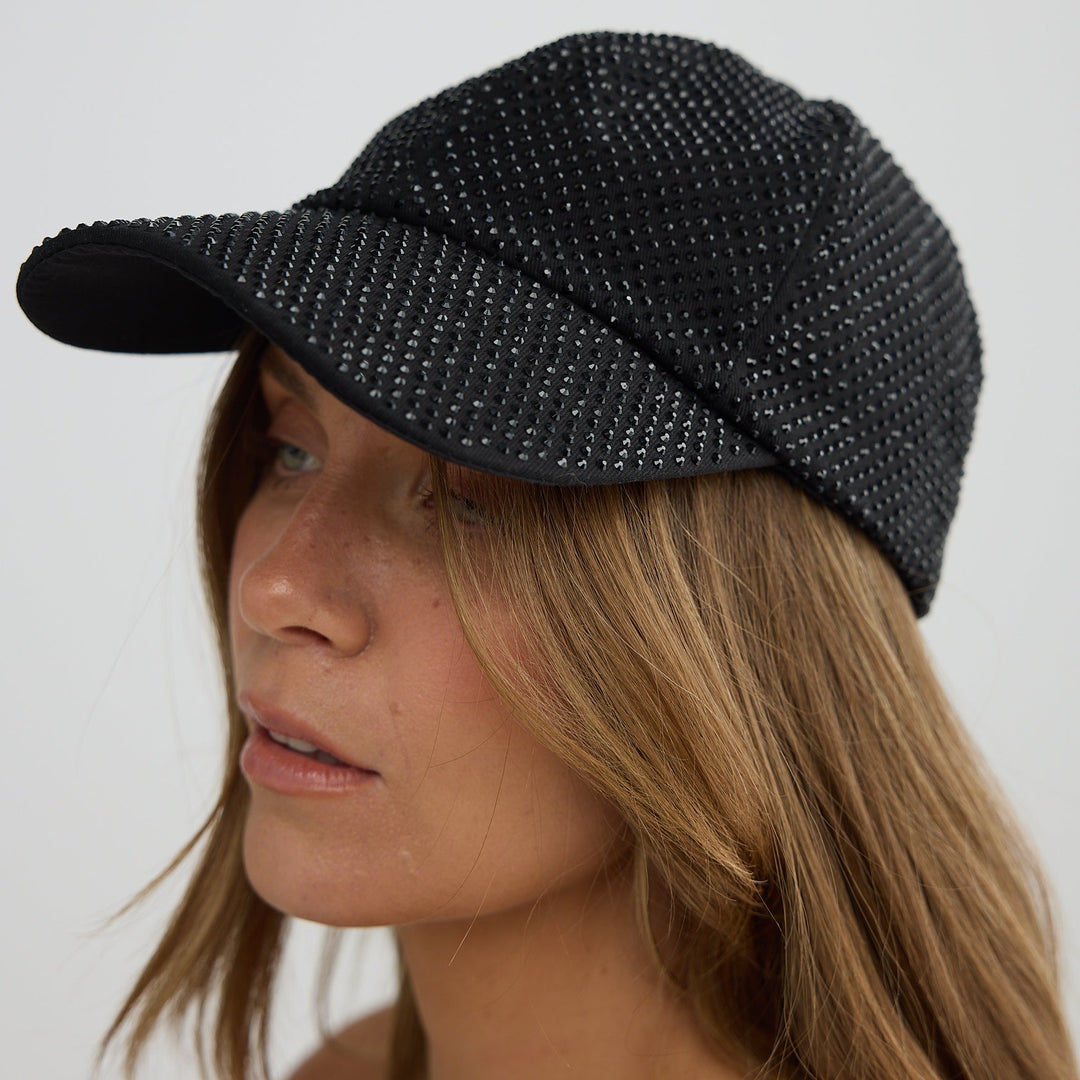 Woman wearing a black textured cap against a white background