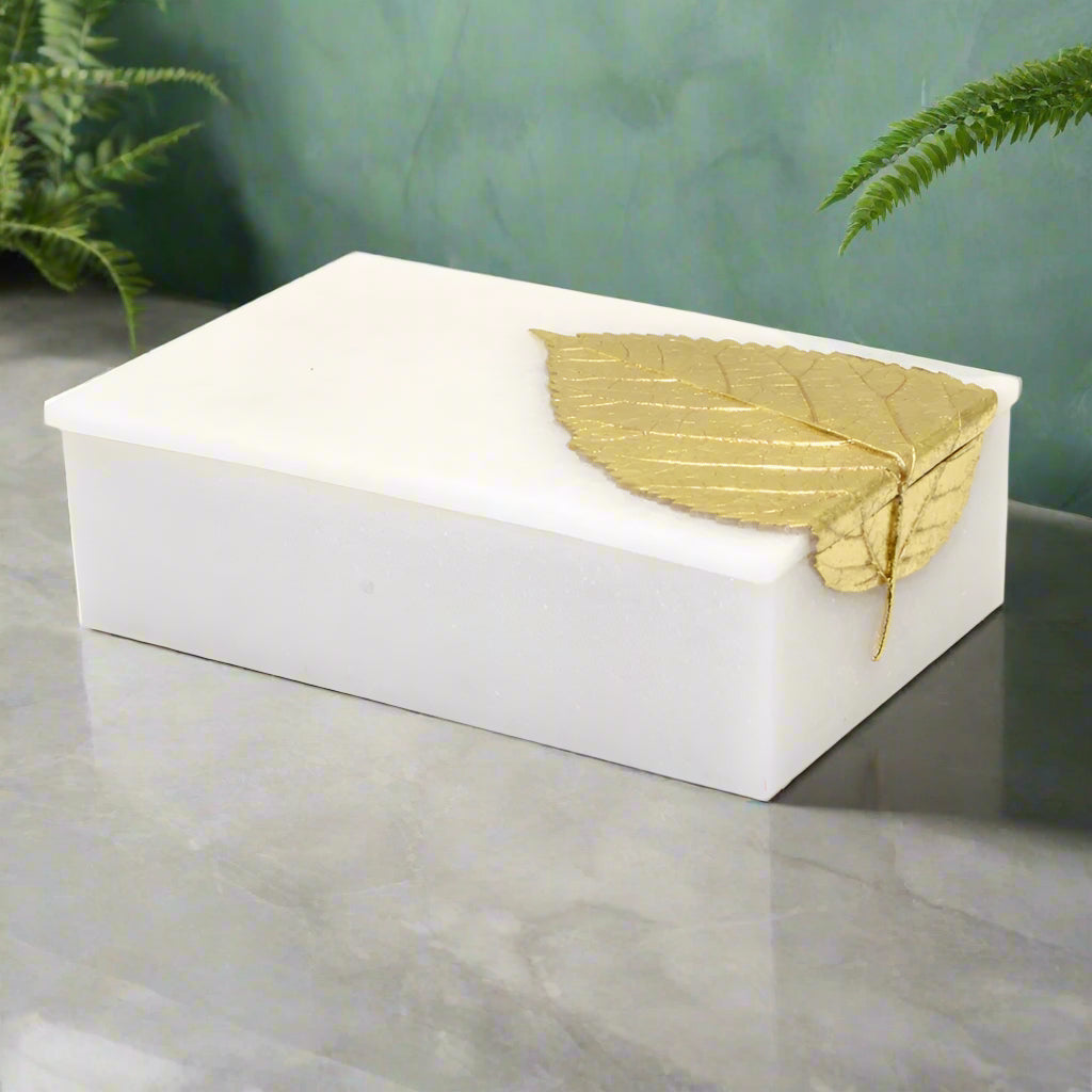 White rectangular box with a gold leaf on a white background