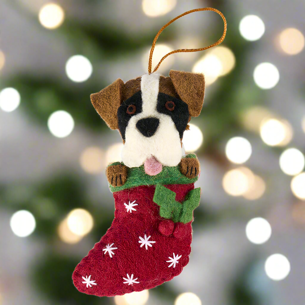 Dog-themed Christmas ornament with a red stocking and white snowflakes on a white background
