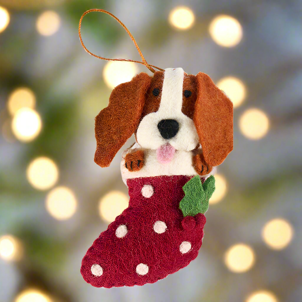Felt dog ornament with a red stocking on a white background
