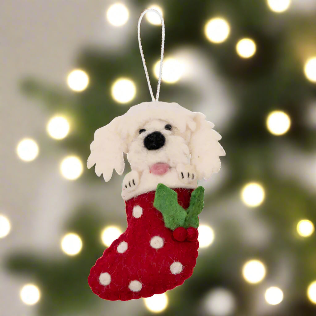 Felt dog in a red stocking ornament on a white background