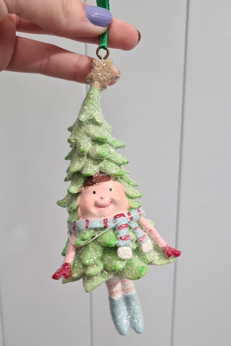 Decorative fairy figurine hanging from a string against a plain background