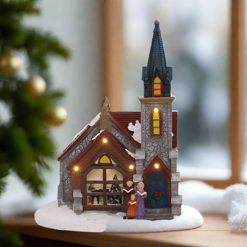 Decorative model of a church with LED lights on a white background