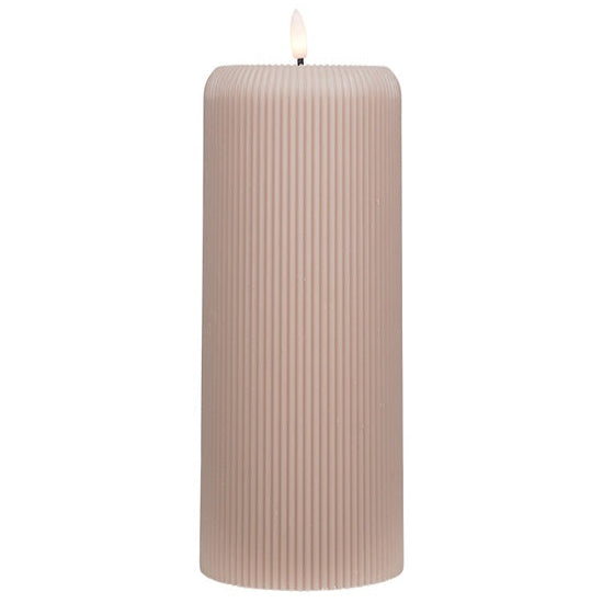 Beige ribbed candle on a white background