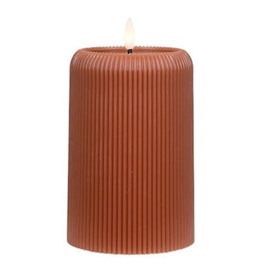 Brown ribbed candle on a white background