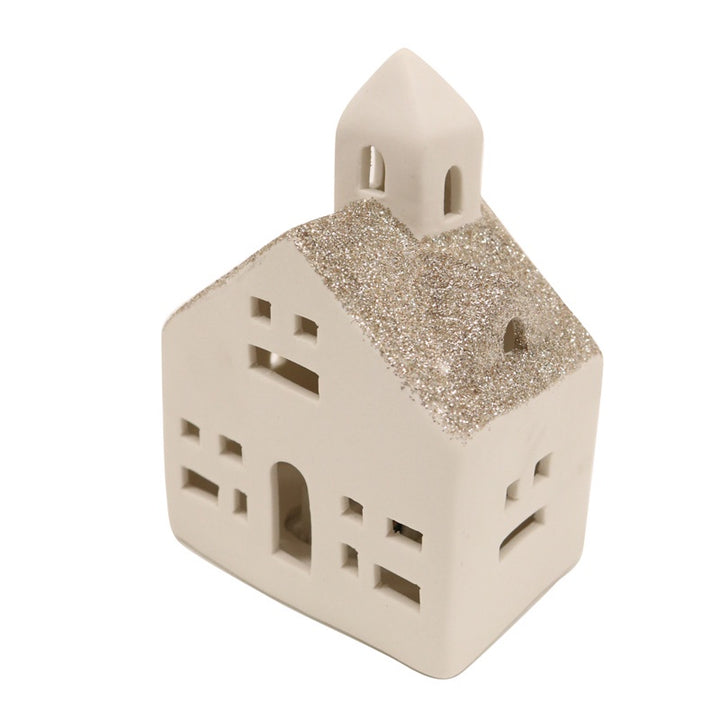 Ceramic house-shaped lantern with glittery roof on a white background