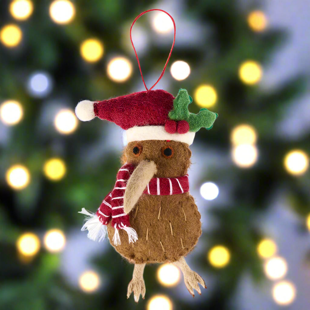 Christmas-themed ornament of a brown creature with a red hat and scarf on a white background