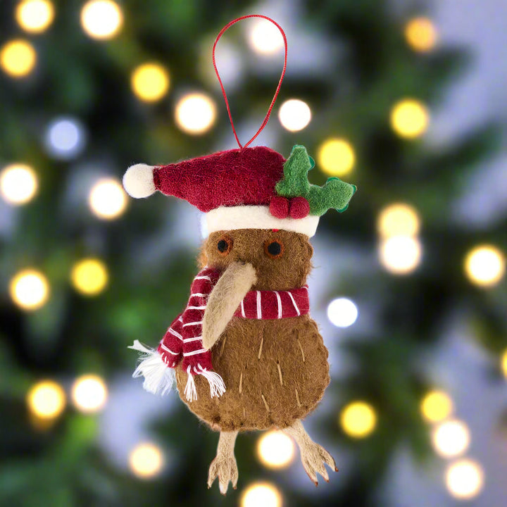 Christmas-themed ornament of a brown creature with a red hat and scarf on a white background